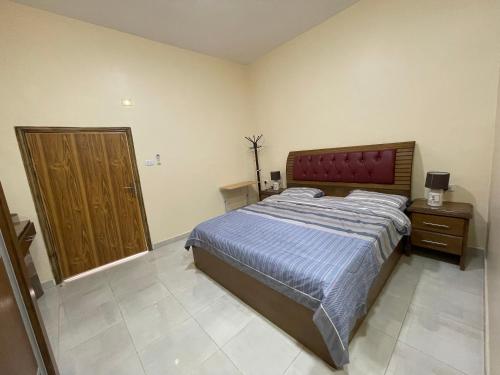 a bedroom with a large bed and a wooden door at Petra 555 Rooms & Apartment in Wadi Musa