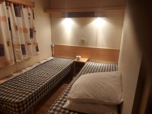 a small room with two beds and a window at mobile home A15 in Boofzheim