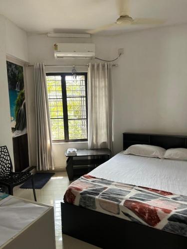 a bedroom with a large bed and a window at Chaithritha Ladies Homestay in Trivandrum