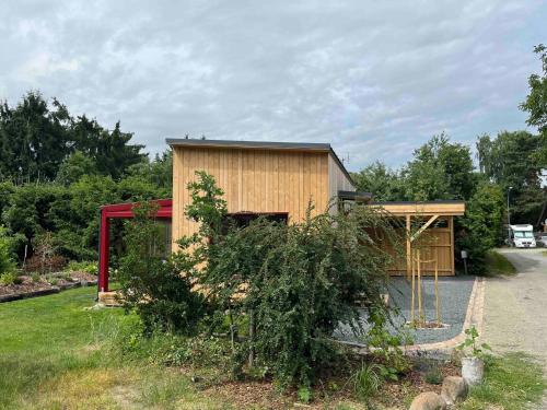 a small wooden building with a fence in a yard at Tiny Frida in Gifhorn