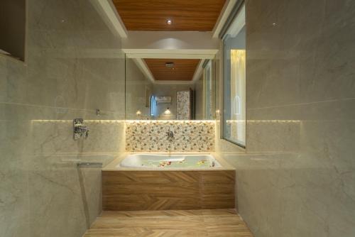 a bathroom with a tub and a mirror at Hotel Royal Inn in Thane