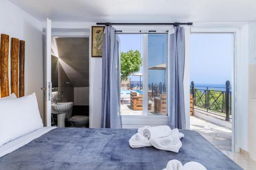 a bedroom with a bed and a view of the ocean at Villa Sea Horizon in Skopelos Town