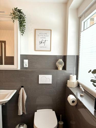 a bathroom with a white toilet and a sink at Ferienhaus Sandstrand in Cuxhaven