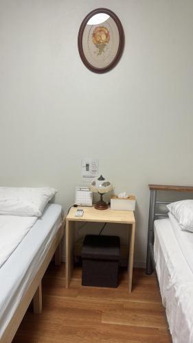 a bedroom with two beds and a desk with a mirror at Waraku No2,Guesthouse near KIX in Izumi-Sano