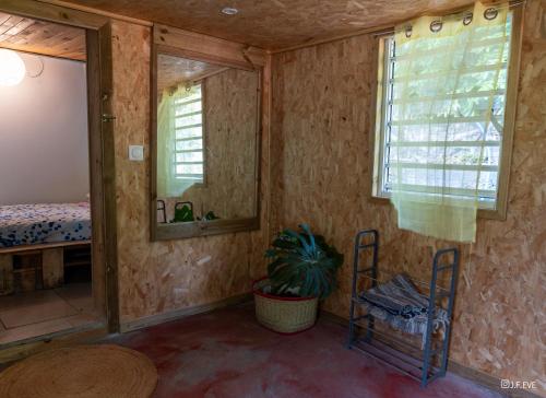 a room with a bed and two mirrors and a table at Ti kaz gogo in Salazie