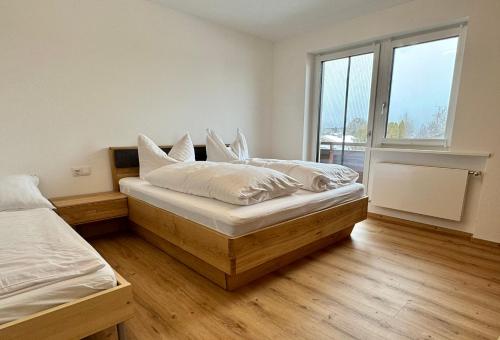 two beds in a room with wooden floors at Apartment Angela in Mittersill