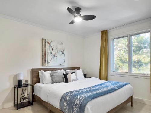 a bedroom with a bed with a ceiling fan at Hot Tub with Backyard Play Area in Toronto