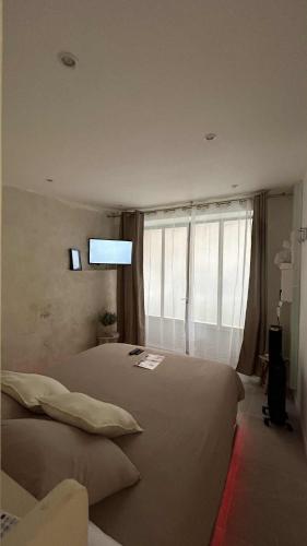 ein Schlafzimmer mit einem großen Bett und einem großen Fenster in der Unterkunft L'intrAMOURos in Avignon