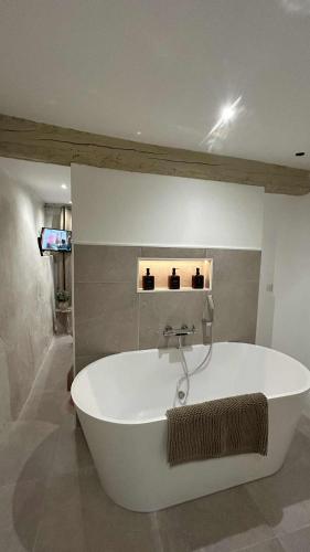 eine große weiße Badewanne in einem Zimmer in der Unterkunft L'intrAMOURos in Avignon