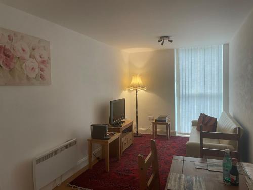 a living room with a couch and a television at York House Apartments in Romford