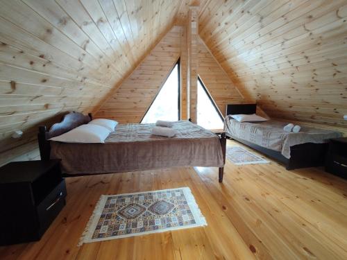 a room with two beds in a wooden cabin at Lasha's Cottage in Mestia