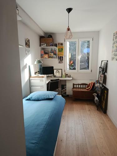 a bedroom with a bed and a desk in it at Chambre et Salle de bain privées avec vue sur jardin dans maison familiale in Montreuil