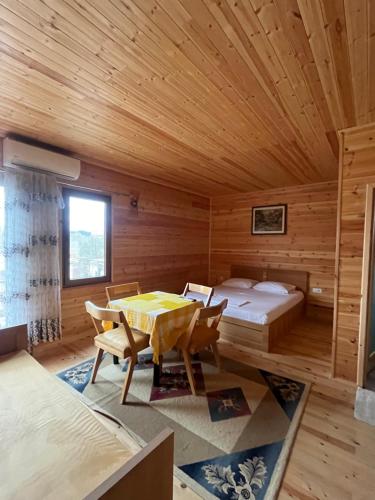 a room with a bed and a table and chairs at Villa Argjiro in Draç