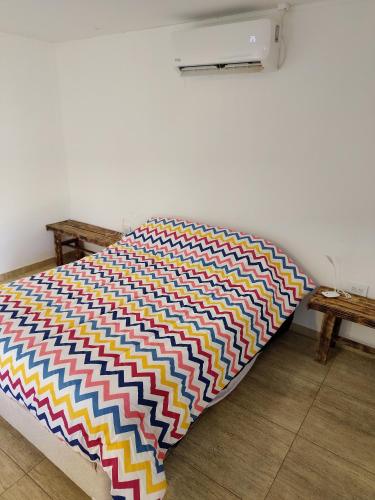 a colorful blanket on a bed in a room at Quincho Monoambiente Con Parrilla in Balcarce