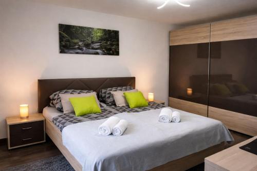 a bedroom with a bed with green and white pillows at Oaza Resnik in Zagreb