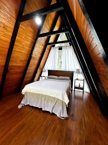 a bedroom with a white bed in a attic at Chalé Montem Verde I Refúgio na Serra Catarinense em Ponte Alta com Hidro próximo Lages, Urubici in Ponte Alta