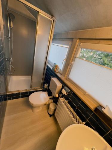 a small bathroom with a toilet and a shower at Pension Werre Stern self check-in ,nähe Werre Park in Bad Oeynhausen