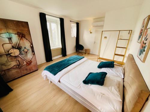 a bedroom with a bed with green pillows on it at Hypercentre, spacieux, lumineux, climatisé, le Quai de Loire in Blois