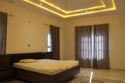 a bedroom with a bed and a yellow ceiling at MB Properties - situated behind Dalaba Estate about 500 meters from the famous OIC road in Madina Sey Kunda