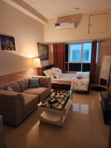 a living room with a couch and a bed at Studio in Ajman in Ajman 