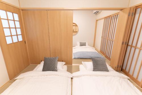 a small room with two beds in it at 大吉屋本館 ワンフロア貸切部屋 名駅離れ in Nagoya