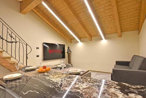 a living room with a couch and a tv at ArtiStone - "The Modern Loft" - Nature and Relax in Saint-Christophe