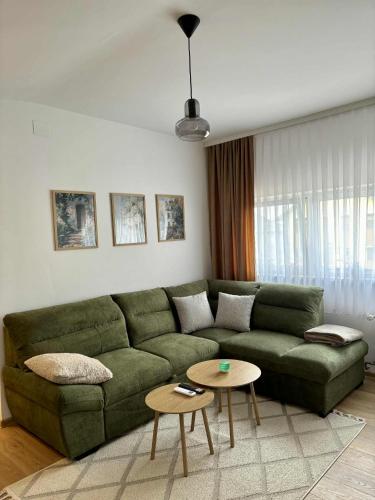a living room with a green couch and a table at Apartman Lukas in Županja