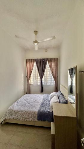 a bedroom with a large bed and a window at Ayu Homestay Kuantan in Beserah