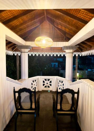 two chairs sitting on a porch with a chandelier at Yahana Beach Villa in Negombo