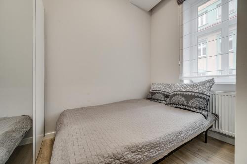 a small bed in a room with a window at Central Platinum Apartments 8 in Rybnik
