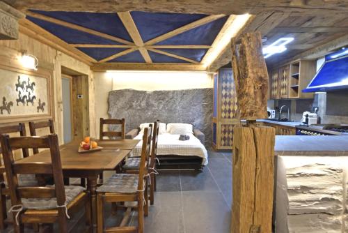 a kitchen with a table and a bed in a room at ArtiStone - "Ancient Lodge" in Saint-Christophe