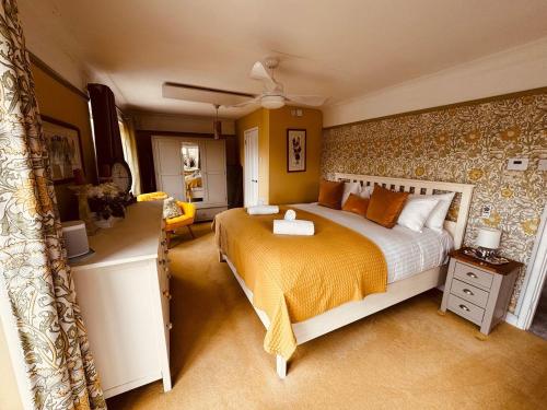 a bedroom with a large bed with yellow walls at 2-Bed Coastal Haven with Private Hot Tub in Lowestoft