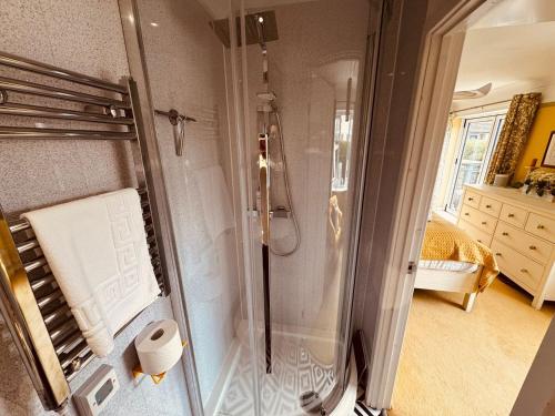 a bathroom with a shower and a toilet paper roll at 2-Bed Coastal Haven with Private Hot Tub in Lowestoft