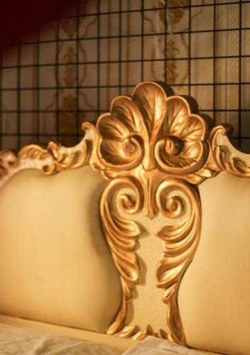 a gold bed frame with a flower design on it at Jessica Flat Malta Royal Guesthouse in Cospicua