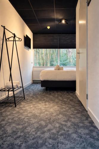 a bedroom with a bed and a large window at Buitengoed Fredeshiem in De Bult