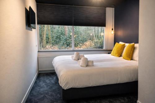 a bedroom with a large bed with a window at Buitengoed Fredeshiem in De Bult