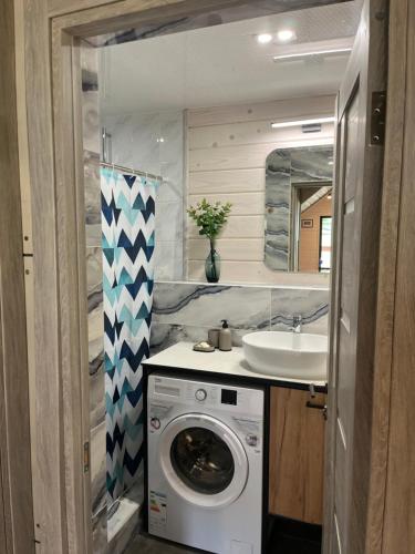 a bathroom with a washing machine and a sink at Шале 1077 метрів над рівнем моря in Krivopolʼye