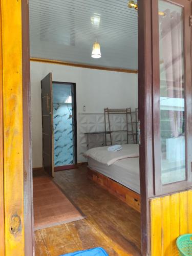 a small bedroom with a bed and a mirror at Jambu Tree Homestay in Tanjungjati