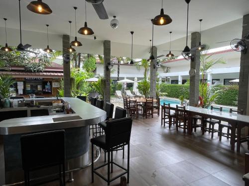 a restaurant with a bar and tables and chairs at Lotus Bleu Resort & Restaurant in Rawai Beach