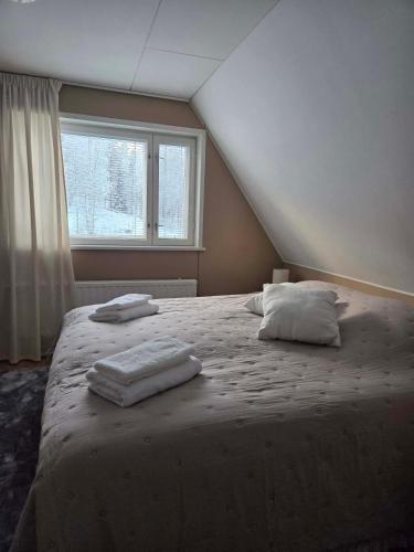 a bedroom with a large bed with two pillows on it at Leinosen Lempi in Ylämylly