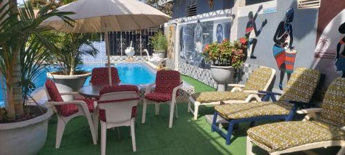 a patio with chairs and a table and a pool at Sweet Mama in Bijilo