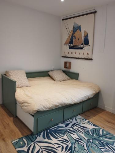 a bedroom with a bed with a painting on the wall at Appartement moderne, vue mer in Luc-sur-Mer