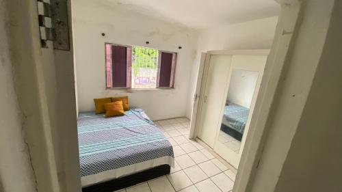 a small room with a bed and a mirror at Casa Carnaval Olinda 2026 in Recife