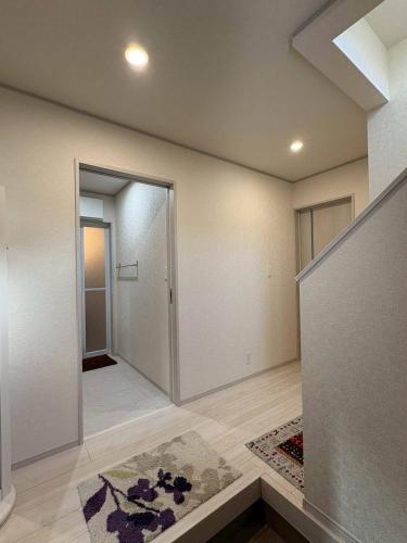 an empty room with a hallway with a door at 青梅森の宿3号館新築一棟貸し東青梅駅徒歩3分最大11人 in Ome
