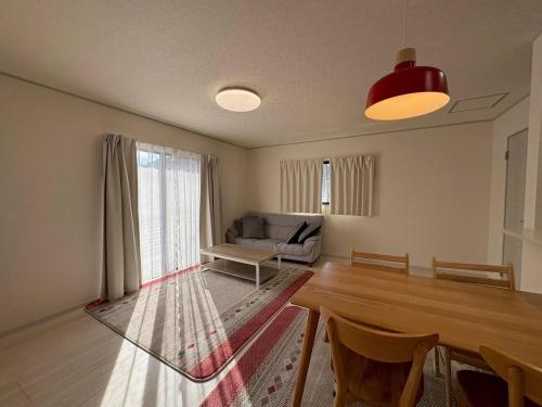 a living room with a table and a couch at 青梅森の宿3号館新築4房車站4分 in Ome