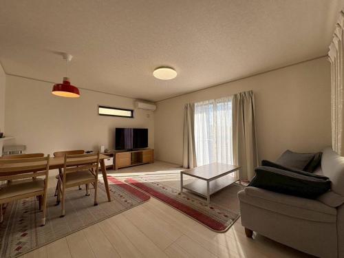 a living room with a table and a dining room at 青梅森の宿3号館新築4房車站4分 in Ome