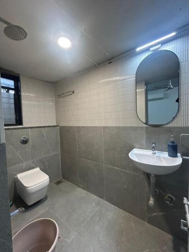 a bathroom with a sink and a toilet and a mirror at Tripvana Backpacker Hostel in Nashik