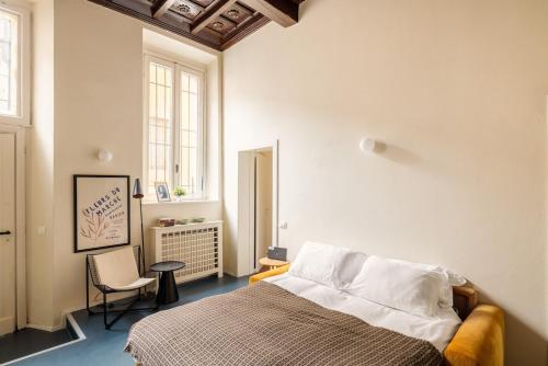 a bedroom with a bed and a chair and a window at Dal Cardinale in Novara