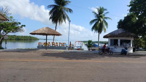 a man riding a motorcycle next to a building next to the water at Varandas do mar II in Abade