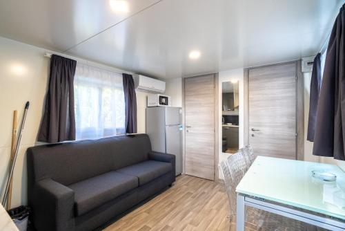 a living room with a couch and a refrigerator at Camping&Village Le Cernie in Lotzorai